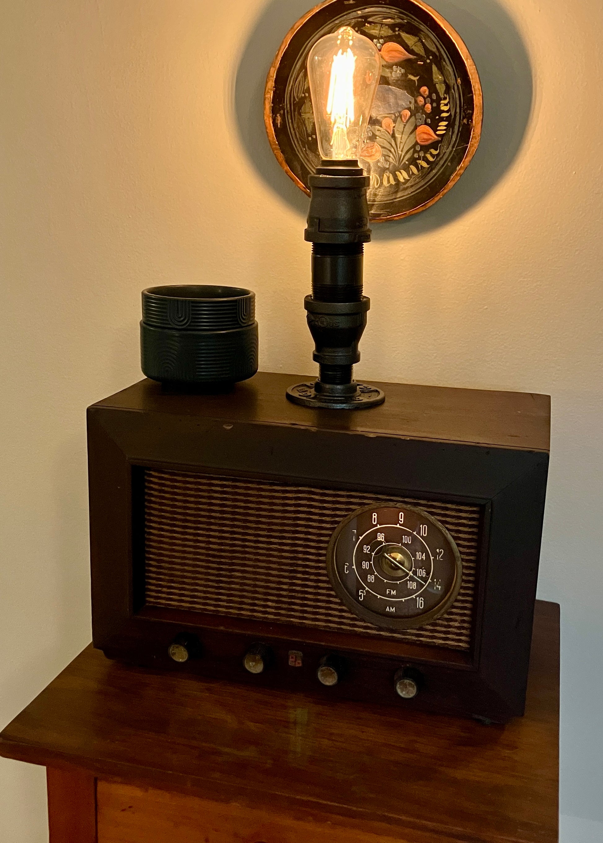 Picture of an antique tube radio turned into lamp with iron pipe and smart bulb